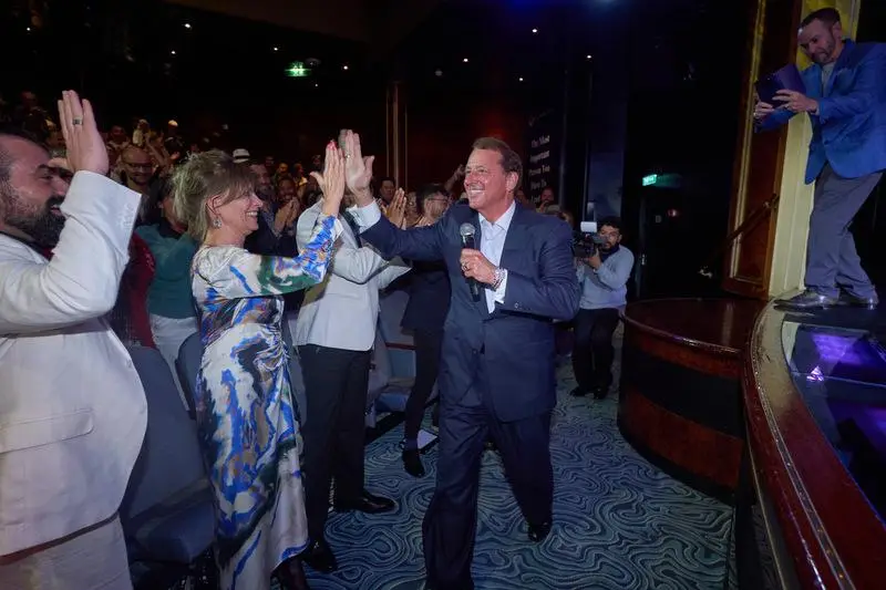 Kevin Trudeau high-fiving audience members at a live event